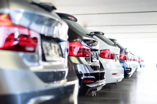 Parking extérieur avec rangées de véhicules stationnés sous éclairage naturel
